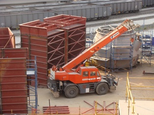 Crane lifting baghouse module during industrial installation